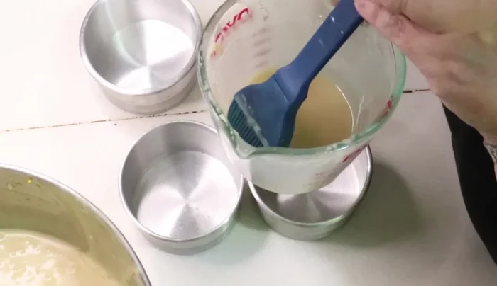 Prepare the muffin tins by greasing them with a mixture of vegetable shortening and flour.