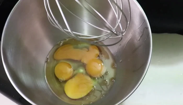 Crack the eggs into a bowl and add a pinch of salt. Beat for 5-6 minutes at high speed using a mixer.