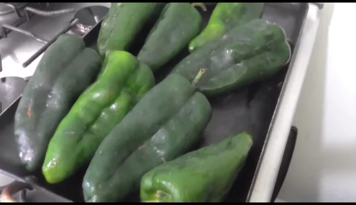 Roast poblano peppers on a griddle until the skin starts to burn. Place them in a plastic bag to sweat and make peeling easier.
