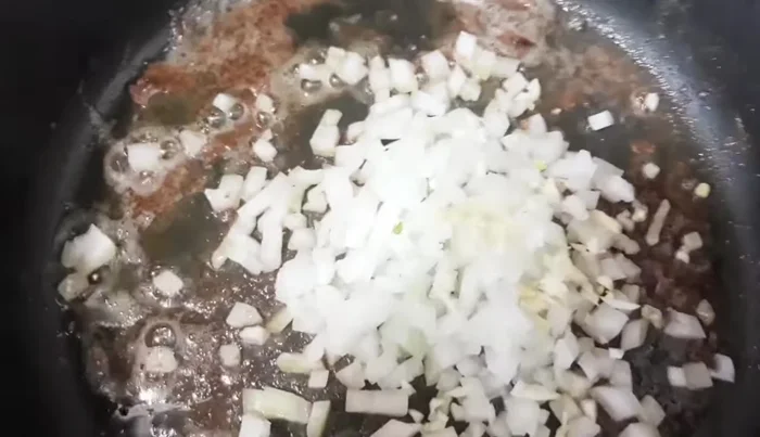 Prepare the sauce: In the same pan, sauté chopped onion and garlic.