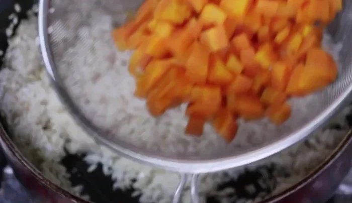 Add the cooked carrots to the rice. (294.479)