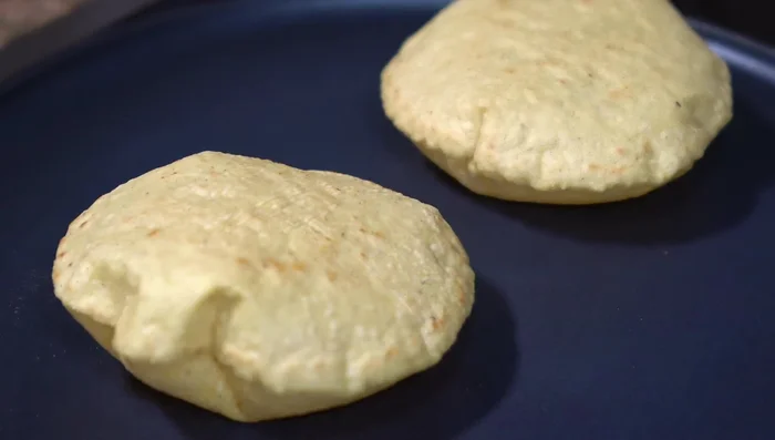 Assemble empalmes: Spread spicy lard on a tortilla, add beans, cheese, pork rind filling, and more cheese. Grill until cheese is melted and golden brown.