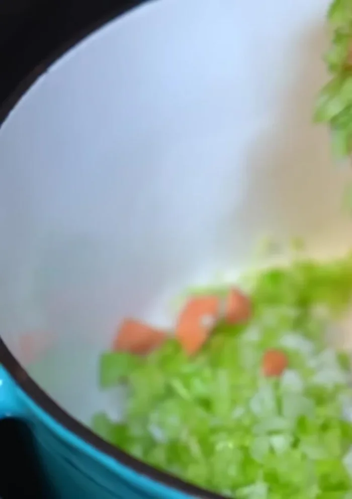 In a separate pot, sauté chopped onion, celery, and carrots in hot oil until softened.