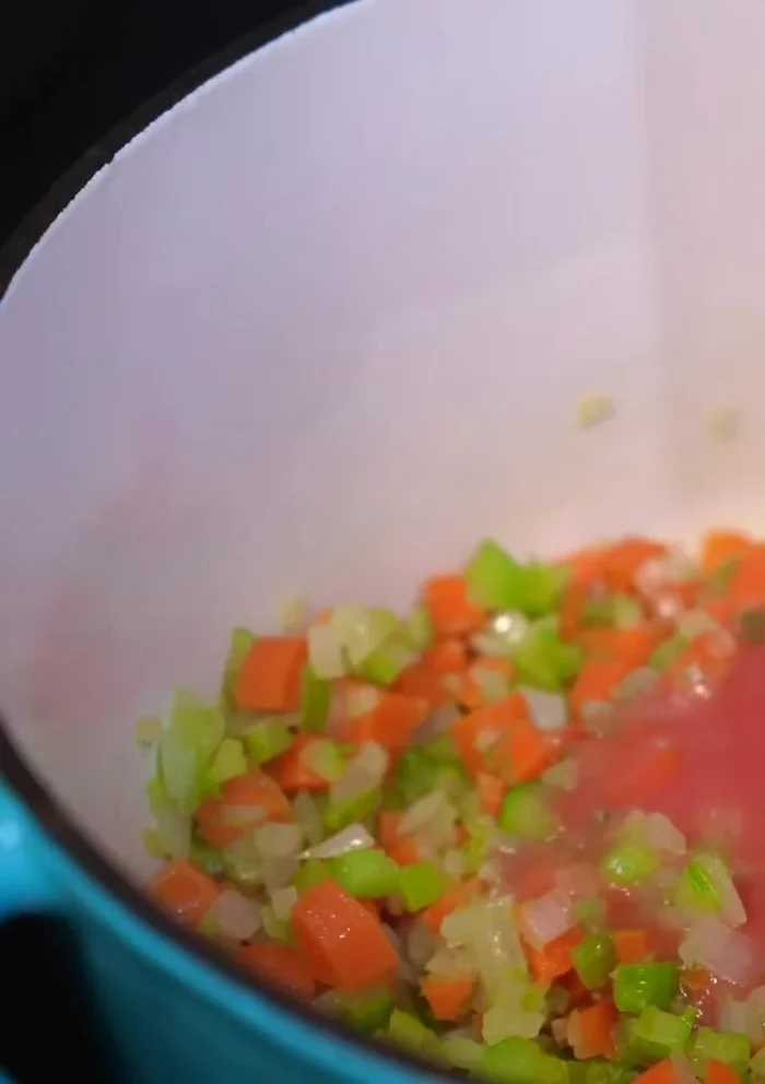 Pour blended tomato mixture into the pot with the sautéed vegetables. Season with salt and simmer.