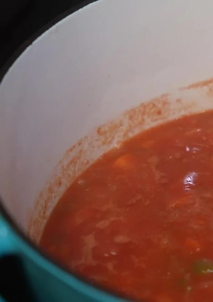 Add cooked chickpeas and their cooking liquid to the pot. Simmer.