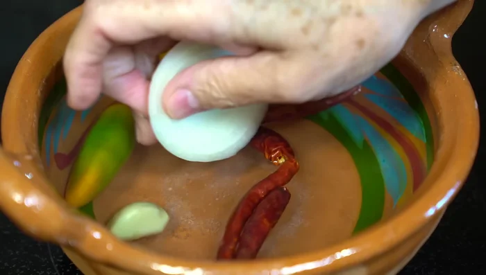 Prepare Huevos Zapateros sauce: In hot water, add salt, serrano chile, chiles de árbol, garlic, and onion. After 5 minutes, add tomatoes. Once softened, blend all ingredients with a little cooking water.