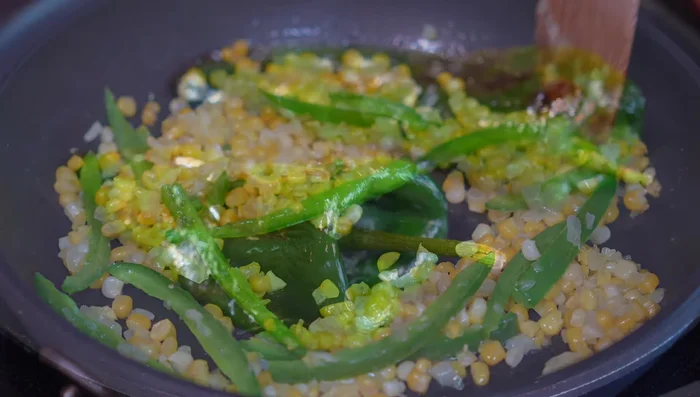 Add the roasted poblano peppers (peeled, seeded, and cut into strips). Cook for 3-4 minutes over medium-low heat.