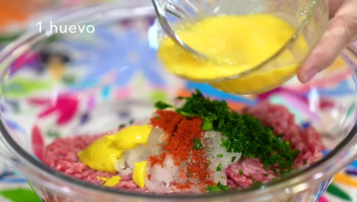 Lightly beat an egg and add it to the meat mixture.