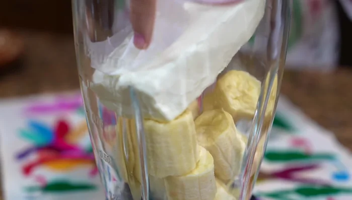 Add bananas (peeled and cut), cream cheese (room temperature), condensed milk, evaporated milk, vanilla extract, and yellow food coloring to a blender. Blend well.