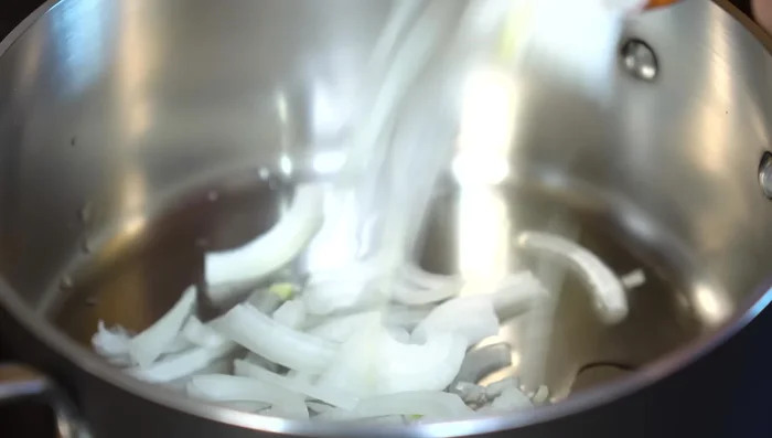 In a separate pan with hot oil, sauté a chopped onion until almost translucent.