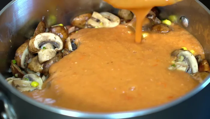 Pour the blended recaudo into the pan with the mushrooms. Lower heat and simmer to allow flavors to meld.
