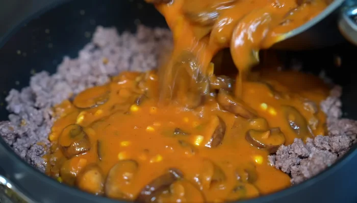 Add the mushroom and recaudo sauce to the cooked ground beef. Simmer for 10 minutes over medium heat until flavors integrate.