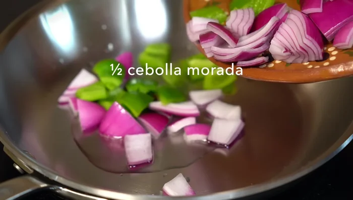 Prepare the recaudo (red sauce base): In hot oil, sauté half a red onion and a green pepper, both cut into pieces. Add thyme and oregano.
