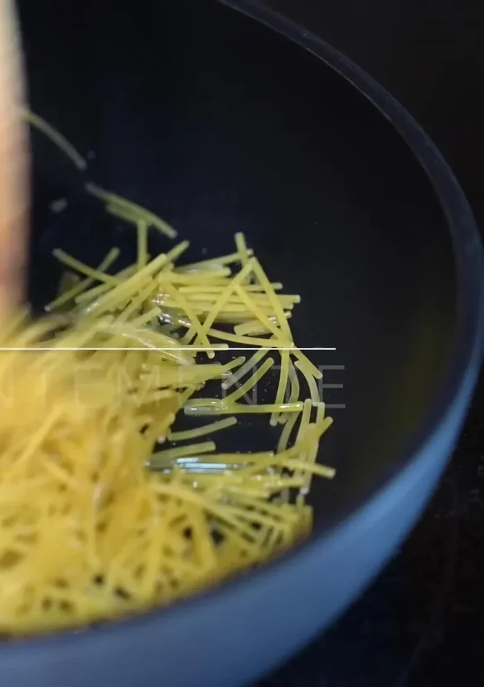 Fry half of the noodles in a pan with hot oil over medium heat until golden brown (about 5 minutes), stirring constantly.