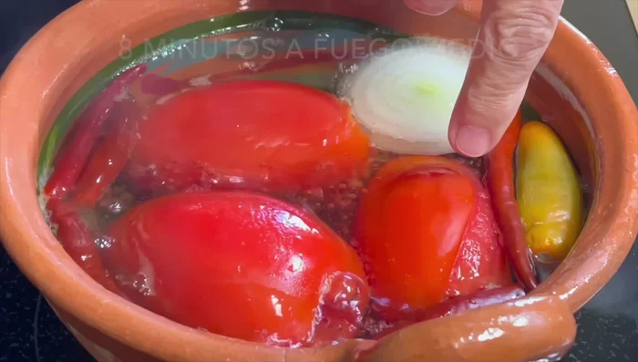 Once the tomato skins burst, remove the tomatoes, chiles, onion, and garlic from the pot.