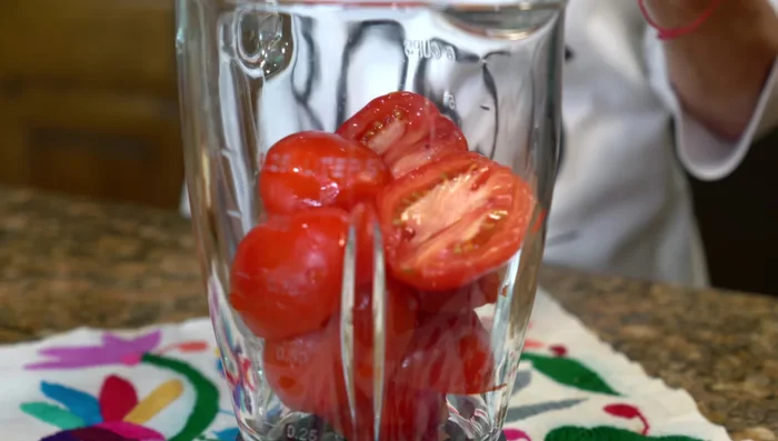 Blend tomatoes, half an onion, and 1 garlic clove with water in a blender until smooth. Strain.