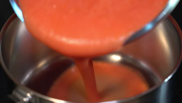 In a saucepan with a little hot oil, add the blended tomato mixture. Season with salt, pepper, oregano, and chicken bouillon powder. Simmer for 5 minutes.