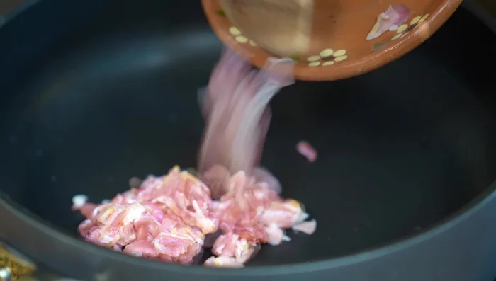 In a hot pan, fry bacon until golden brown. Add butter and minced garlic; stir until fragrant.