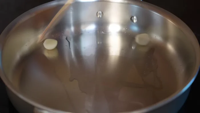 In a pan with hot oil, sauté one garlic clove over medium heat for two minutes. Add onion and sauté until almost caramelized (about five minutes).