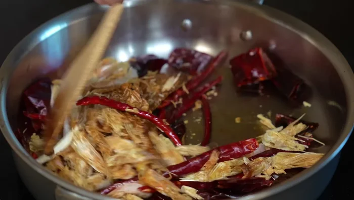 Add shrimp heads and legs and stir until evenly fried. Add tomatoes, cut into pieces.