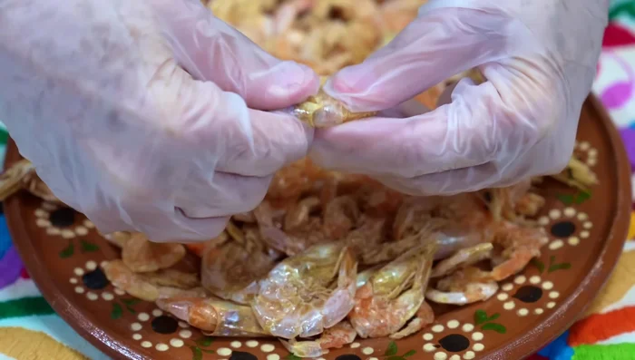 Remove heads and legs from larger dried shrimp; set aside. Leave smaller shrimp whole. Remove shrimp eyes.