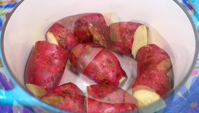 In a pot, arrange sweet potatoes, piloncillo pieces, sugar, broken cinnamon sticks, crushed cloves, and water.
