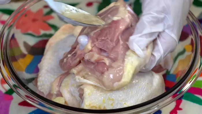 Coat chicken: Spread the marinade evenly over the chicken thighs, lifting the skin to ensure flavor penetrates.