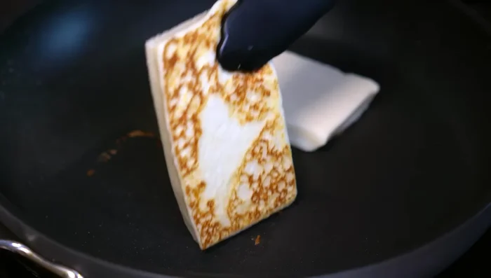 Grill cheese pieces until browned. In a hot pan, fry onion, add sauce, season with salt and cook.