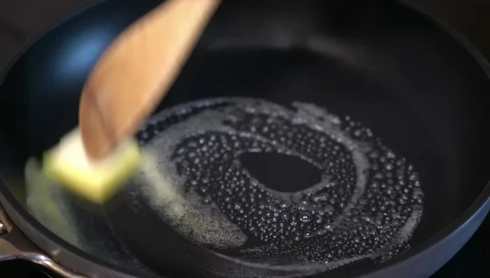 Melt butter in a pan, add garlic, then steamed vegetables and season with salt.
