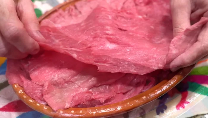 Prepare beef stew ingredients: cut steak into strips, marinate with salt, pepper, vinegar, and soy sauce. Chop garlic and onion.