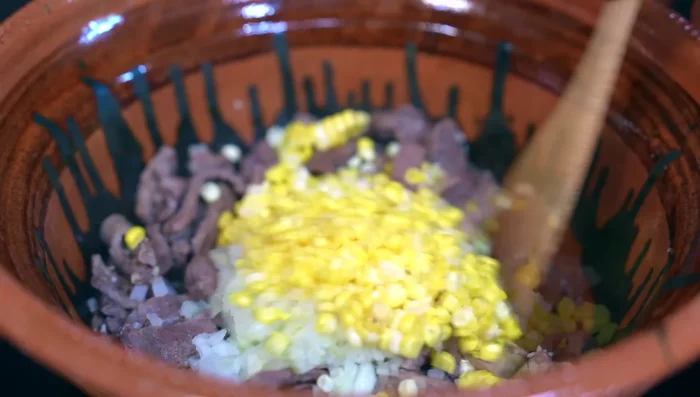 Add corn and fry for 5 minutes. Then add the sauce, season with salt and stir well.