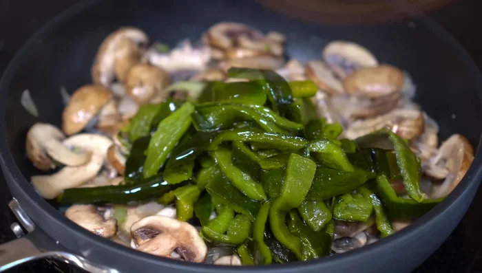 Add poblano pepper strips. Season with salt, lower heat to medium, and cook for 5 minutes.