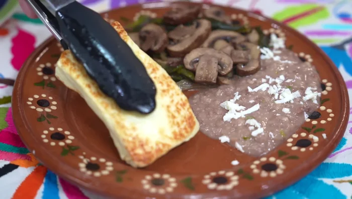 Serve the grilled cheese with the mushroom and poblano stew, refried beans, corn tortillas, green salsa, and pork rinds.