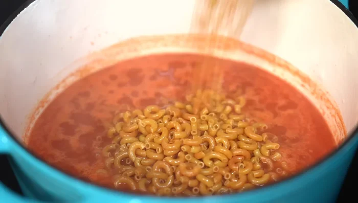 Add the fried macaroni, warm chicken broth, and simmer for 10 minutes.