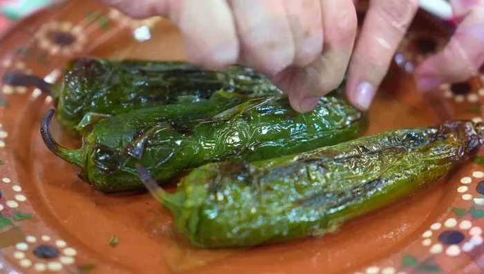 Roast poblano peppers (and jalapeños if desired), peel, and remove seeds.