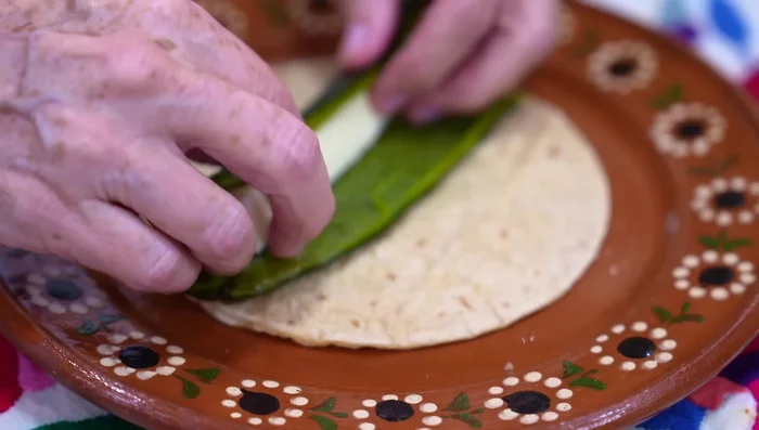 Place a piece of poblano pepper (and/or jalapeño) and cheese onto each tortilla, season, and fold.
