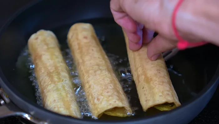 Fry the tacos in hot oil until golden brown on both sides.