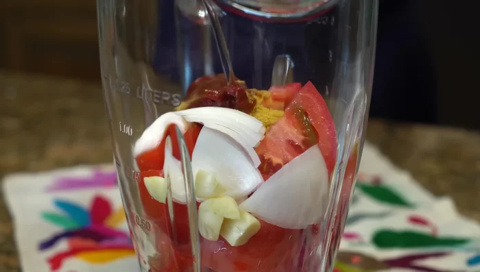 Prepare the tomato sauce: Blend the tomatoes, onion, garlic, chipotle pepper, salt (or chicken broth powder), and a little water in a blender.