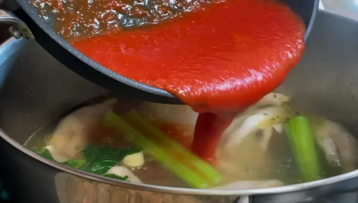 After 30 minutes of simmering chicken feet, add the tomato sauce to the pot.