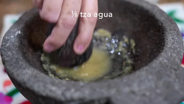 Add water to the molcajete mixture to form a paste.
