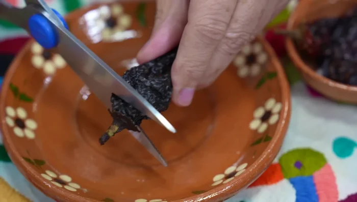 Cut the stems of the Morita chiles with kitchen scissors to help them hydrate.