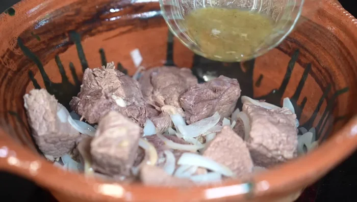 Add the molcajete paste to the meat and onions.