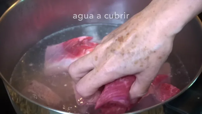 Add beef shank and ribs to boiling water. Cook with half an onion, three cloves garlic, thyme, marjoram, bay leaves, and salt. Stir and cover. Cook for 1 hour 45 minutes over medium heat until tender.