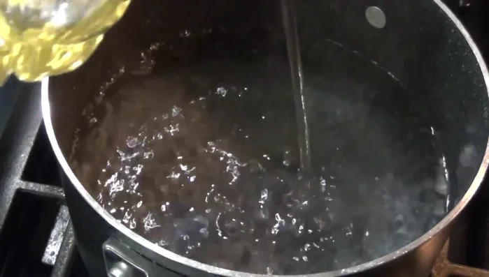 Boil water in a pot. Add a little oil, diced onion, 3 peppers, and 2 cloves of garlic.