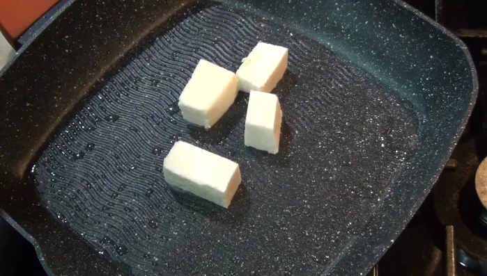 While the stew simmers, cook the cheese on a lightly oiled griddle until melted and golden brown.