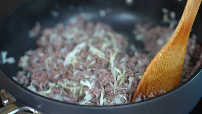 After 5 minutes (medium heat), when the cabbage is soft, add the chopped tomatoes, chiles, and ground spices (cumin, clove, black pepper). Season with salt.