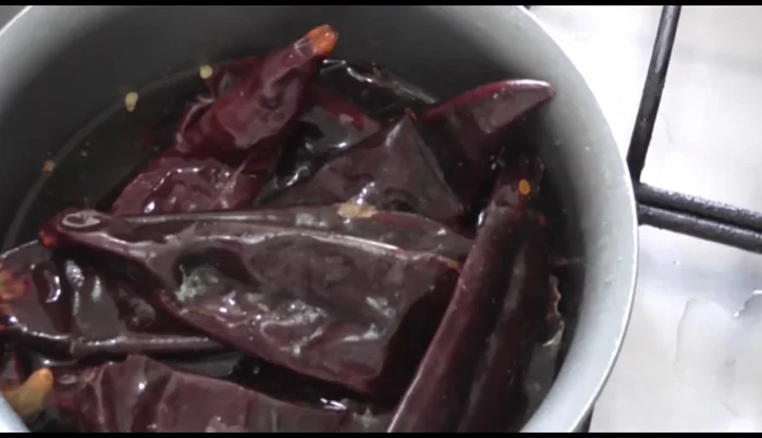 Boil guajillo chiles. Remove stems and optionally seeds. Let them rest for 5-10 minutes after boiling.