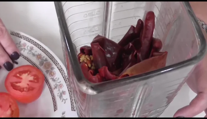 Prepare the chili mixture: blend the boiled guajillo chiles with the serrano peppers, cloves, tomatoes, and ¼ of the onion. Add water to achieve a smooth consistency.