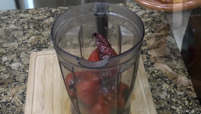 Blend roasted tomatoes, guajillo chili, serrano chilies, garlic, and salt to make the sauce.(127.439)