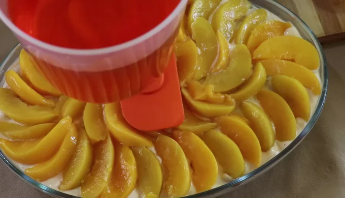 Gently spread the peach jelly over the peaches using a spoon or spatula.